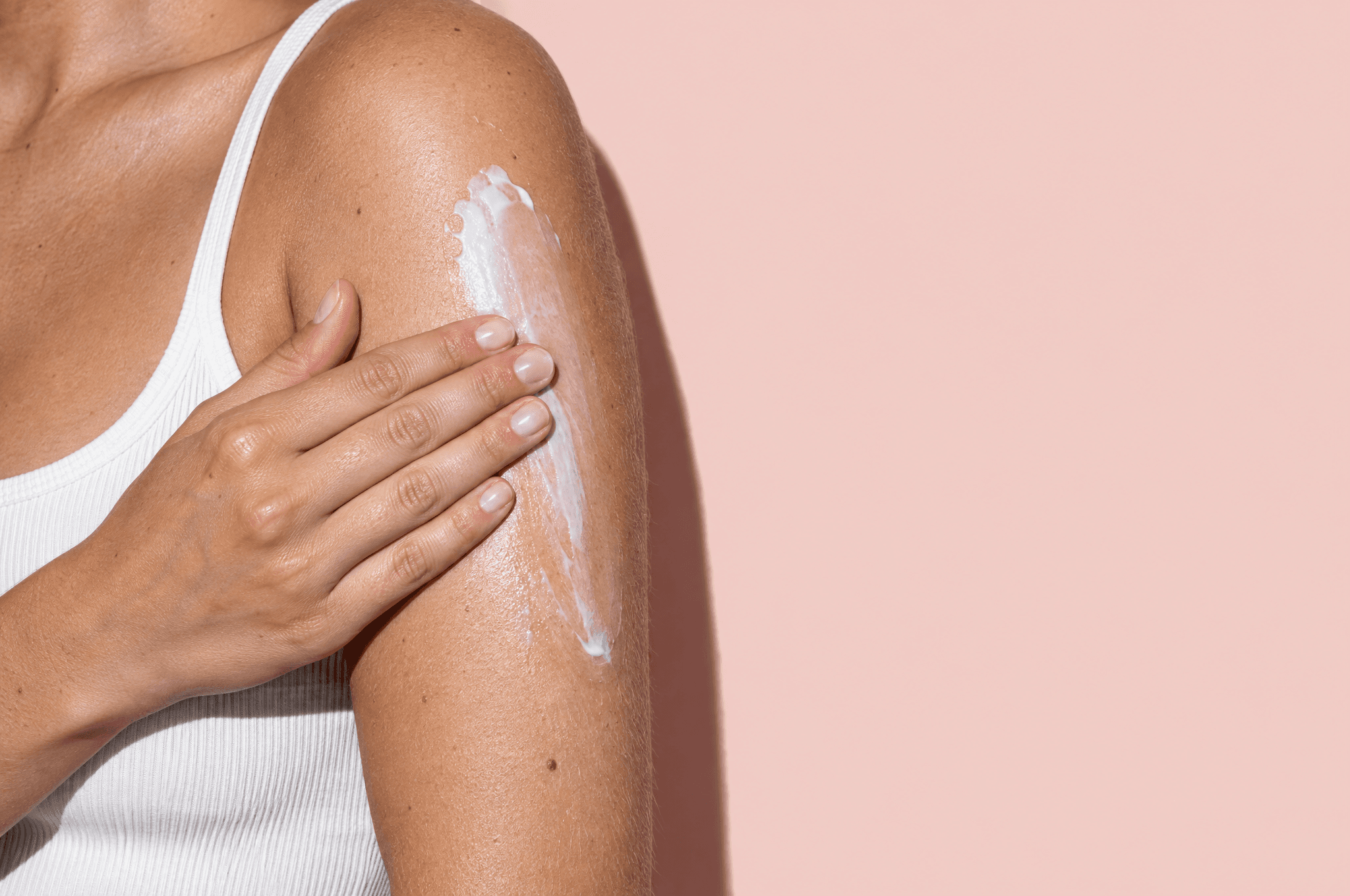 Body lotion being smoothed onto a shoulder and upper arm.